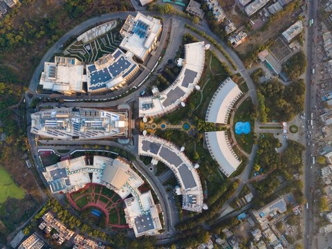 Aerial view of Pune IT Park featuring modern office buildings with curved architecture, landscaped gardens, and solar panels in Pune, Maharashtra, India.