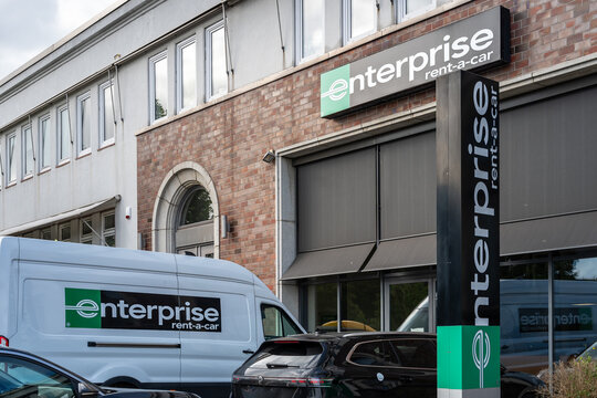Enterprise rent a car branch with large van and cars parked in front of it