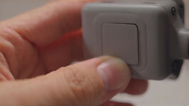 Fingertip pushing a camera privacy switch lever