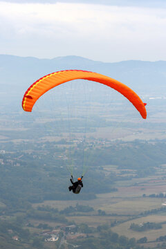 Parapendio in volo panoramico sopra una valle e colline   