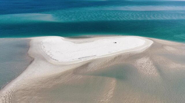 Aerial view of a white sandbar surrounded by turquoise water with ripples in the sand at Amity Point, Queensland, Australia.