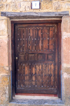 a dark wooden door set into a rustic stone wall.