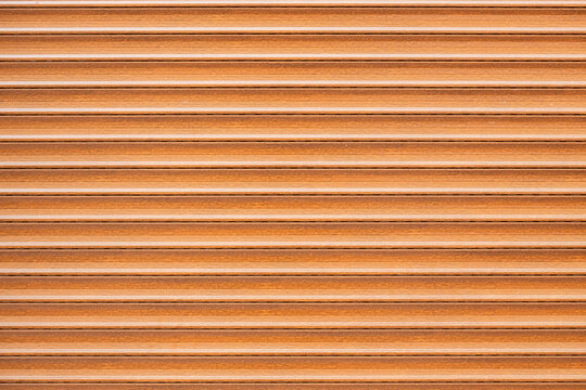 Horizontal wooden slat texture with warm brown tones, layered grain, narrow ridges, and repeating linear pattern for interior surface backgrounds