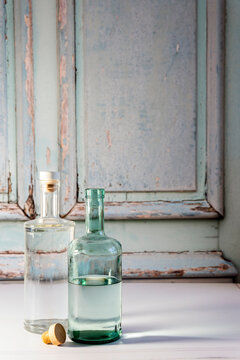 Bottle of open vodka and gin against a weathered door backdrop 