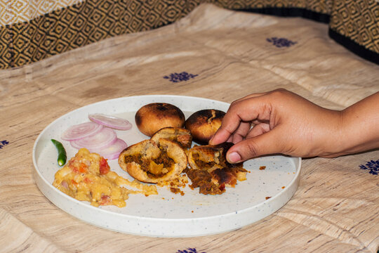 eating litti by breaking it with hand