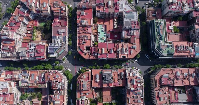 Aerial view of the Eixample district in Barcelona, featuring its iconic grid layout, octagonal blocks, and red-tiled rooftops in Barcelona, Catalonia, Spain.