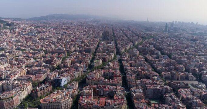 Aerial view of the Eixample district in Barcelona, featuring its iconic grid street layout, historic architecture, and dense urban rooftops in Barcelona, Catalonia, Spain.