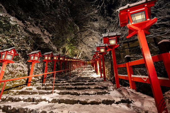 Kifune shrine stone stairs and traditional light pole in snowy winter night, Kyoto, Japan.