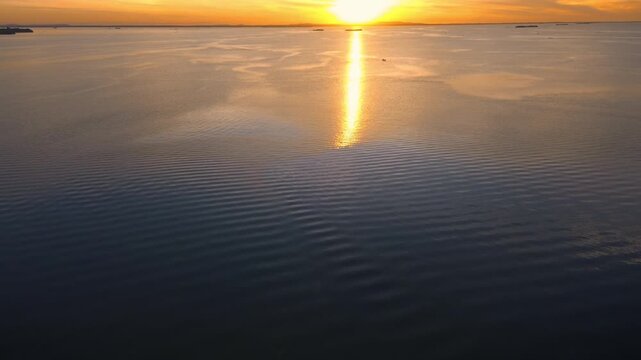 Sunset panorama over calm Pueblo Viejo lagoon with orange sky reflection on water and dusk settling on opposite shore aerial drone POV shot near Tampico Ciudad Cuauhtemoc Veracruz Mexico