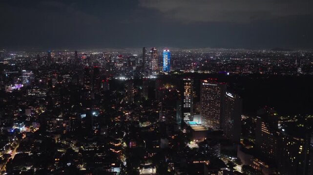 Aerial view of the illuminated night skyline of Mexico City with glowing skyscrapers and urban lights in Mexico City, Mexico City, Mexico.