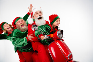 Fototapeta premium Santa Claus and cheerful elves riding a red scooter together, laughing and celebrating Christmas with festive costumes and joyful holiday spirit