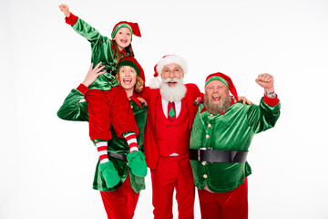 Fototapeta premium Santa and two cheerful elves with a child celebrating Christmas together in festive red and green costumes, smiling and posing for a joyful holiday portrait