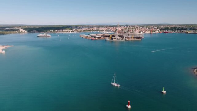 Aerial view of Marina Polesana Pula with shipyard cranes and sailing boats on the blue Adriatic Sea in Pula, Istarska zupanija, Croatia.