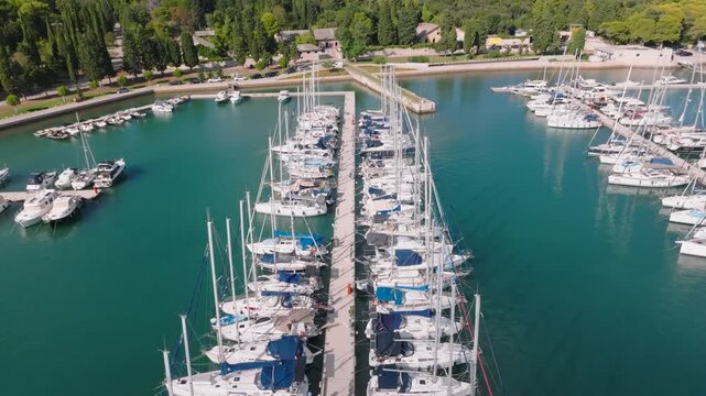 Aerial view of Marina Polesana Pula with numerous sailboats and yachts docked in the turquoise marina surrounded by lush green trees in Pula, Istarska zupanija, Croatia.