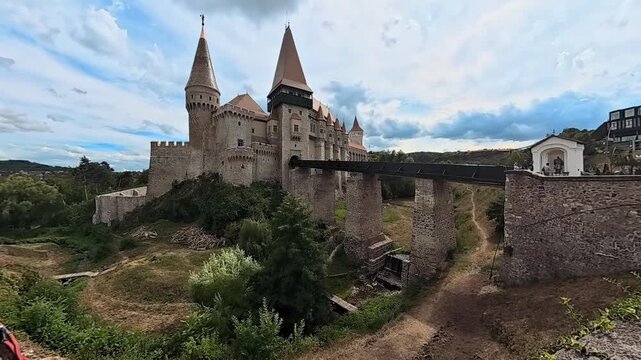 Corvin Castle time lapse with moving clouds over medieval towers and stone bridge, Hunedoara, Transylvania, Romania