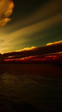 A sunset scene at the ocean shows colorful clouds in the sky. The water below reflects the changing colors as the day turns to night. The view captures a moment of nature.