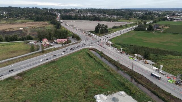 Aerial View Of Vehicles Driving On The Highway Along The Construction Of Surrey Langley Skytrain Line In Surrey, BC, Canada.- hyperlapse shot