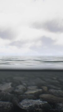 Water flows gently near the shore, reflecting the light from above. Clouds are visible in the sky, adding detail to the atmosphere.