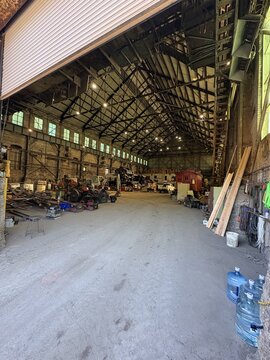 Interior of large empty industrial shed with steel roof trusses