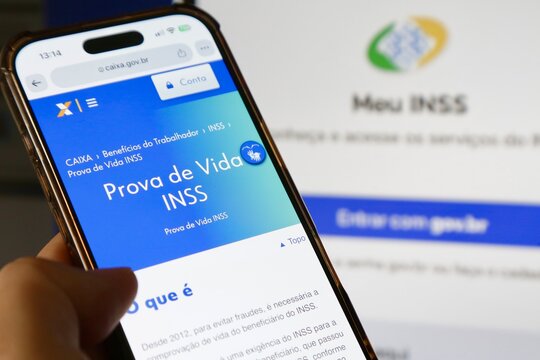 Aplicativo prova de vida do INSS na tela do celular com fundo desfocado.