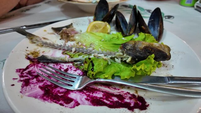Seafood Leftovers on Used Plate at Restaurant Table