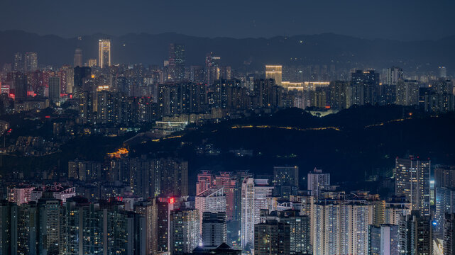 Night view of Chongqing city skyline with illuminated skyscrapers and mountains