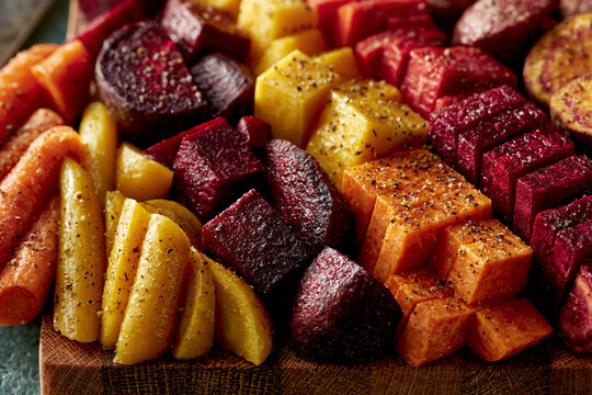 Roasted root vegetables on a rustic wooden board with organic food roasted carrots roasted beet