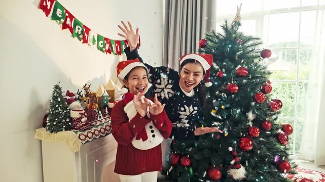 Happy Mother and Daughter Celebrating Christmas Beside Festive Tree