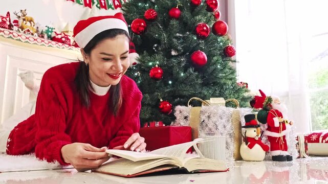 Woman Reading Christmas Book Beside Decorated Holiday Tree