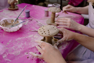 Woman decorating a handmade clay mushroom during a pottery workshop. © sav_an_dreas
