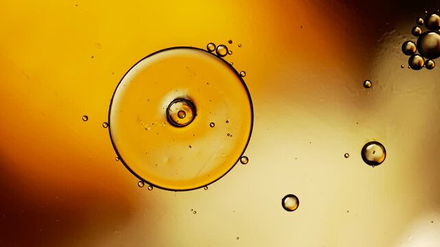 Abstract golden oil bubbles floating on water surface