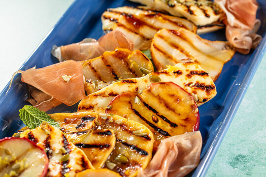 Fresh salad bowl with grilled halloumi cheese and roasted pear and apples, seeds.
