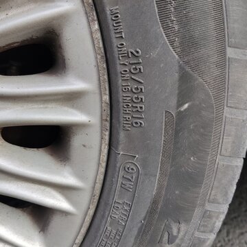 Tire with the numbers 271 on it. The tire is black and has a worn out appearance