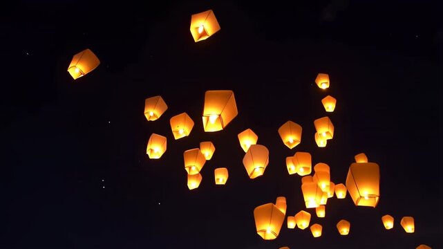 Glowing paper sky lanterns drifting upward in starry night sky festival release 60 FPS