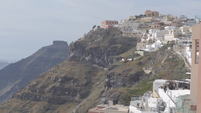 Beautiful scenic view of the village of Fira built on the edge of the volcanic caldera in Santorini, Greece with Skaros Rock in the background