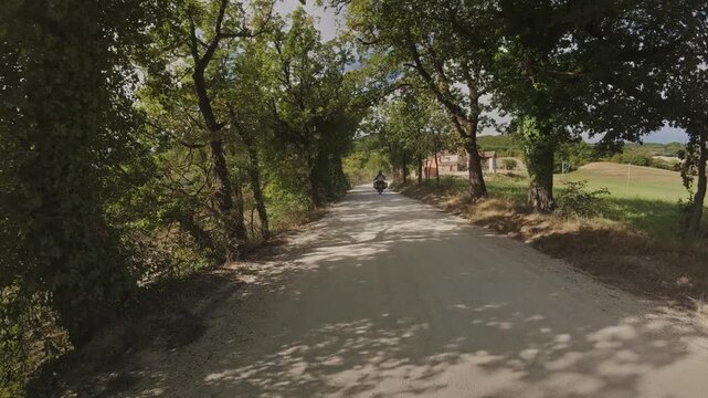 A tracking shot of motorcyclists riding on a gravel road near Ancona, Italy