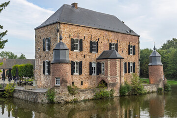 Kerkrade, Netherlands - Detail facade view of historic Kasteel Erenstein showing brick architecture, corner turrets, and moat water. © PixelBiss