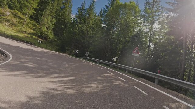 A tracking shot moving down a winding road in the Dolomites, Italy