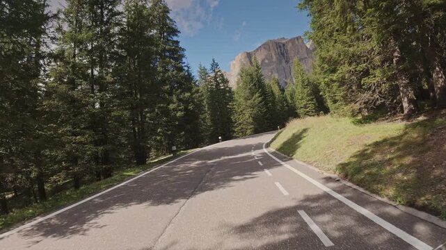 A tracking shot moving down a winding road in the Dolomites, Italy