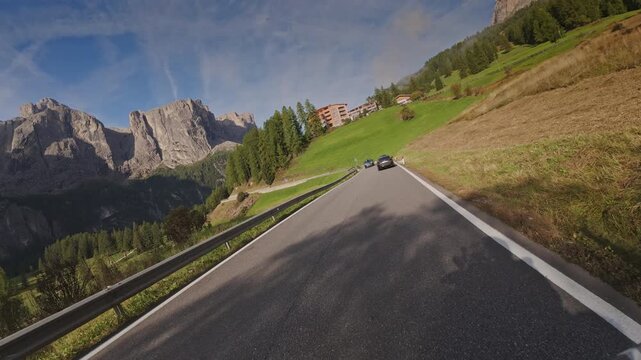 Atracking shot moving down a winding road near Colfosco and the Gardena Pass, Italy