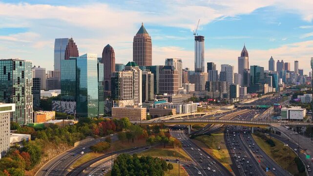 Multi-lane expressway weaving through Atlanta cityscape with skyscraper buildings and heavy traffic. High-speed transportation in modern American city
