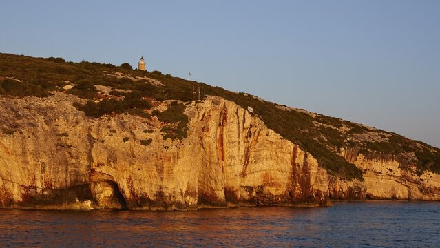 Blue Caves, morning light, lighthouse, rocky coast, blue cloudless sky, northeast coast, Zakynthos Island, Ionian Islands, Greece
