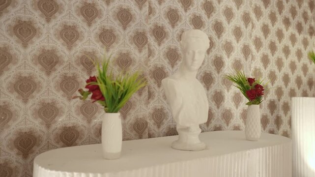 Close-up of Greek Style Marble Bust Sculpture Flanked by Flower Vases on Table