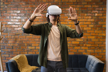 African American man wearing white VR headset, gesturing at home near blue sofa, wristwatch © WavebreakMediaMicro