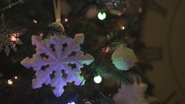 Shiny ornaments and blinking fairy lights on a Christmas tree at night, capturing the warm and joyful atmosphere of the holiday season.