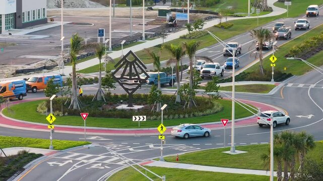 Traffic infrastructure in USA. Road roundabout intersection with driving cars. Circular transportation crossroads in Florida.