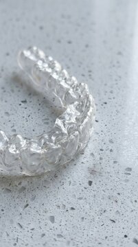 Clear dental aligner tray for teeth straightening on a textured surface