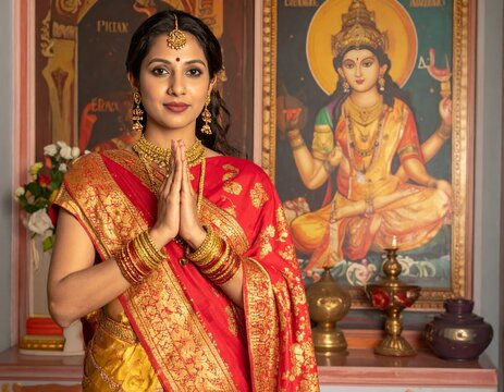 Indian woman performing namaste in a traditional saree
