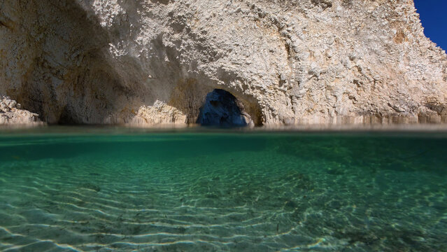 Underwater split photo of beautiful White Sea caves, rock formations and crystal clear emerald calm waters in small cove and beach of Kalami, Kefalonia island, Ioanian, Greece