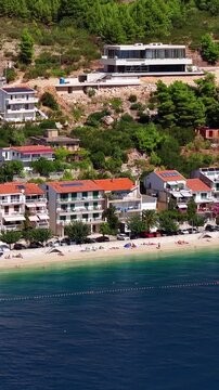 Croatia, aerial view of coastal village with houses, beach, and clear blue sea water